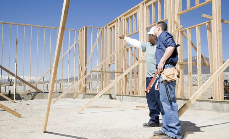 Two builders discussing a timber framing