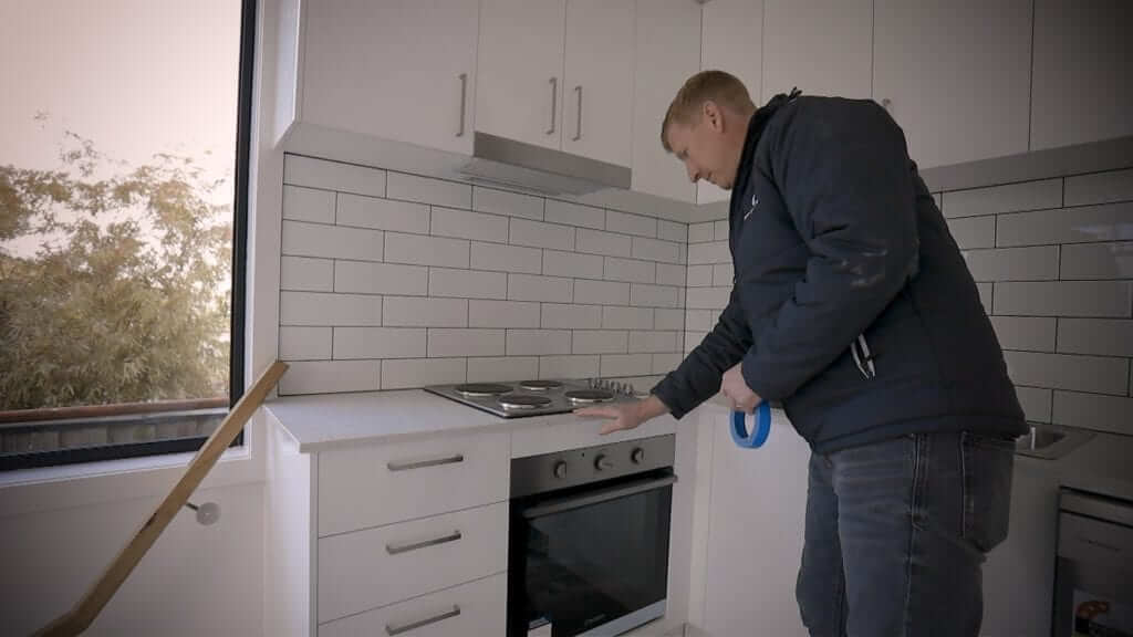 Buildxact customer Bryce Parker looking over a newly installed oven and stovetop