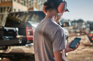 A builder on-site using Buildxact on a mobile phone