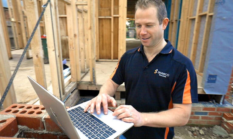 Buildxact customer Hagen Shaw of Shawco using a laptop on a construction site