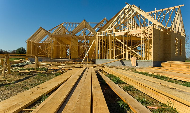 A job site with a nearly completed timber framing