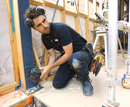 Jack Clough of Nook Construction working with a drill on site.