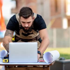 A builder works with construction software while on the job site.