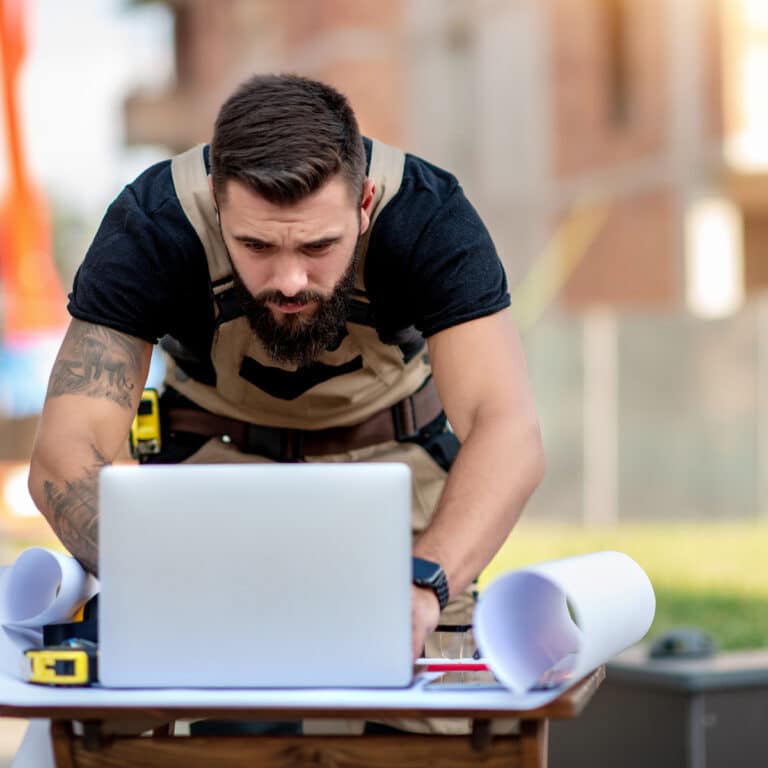 A builder works with construction software while on the job site.