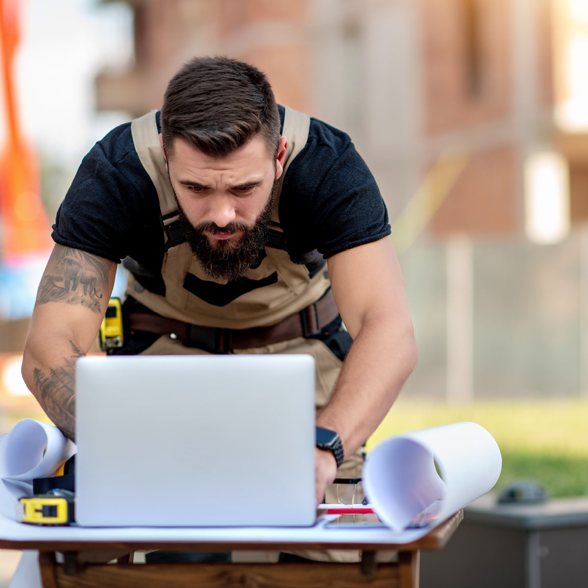 A builder works with construction software while on the job site.