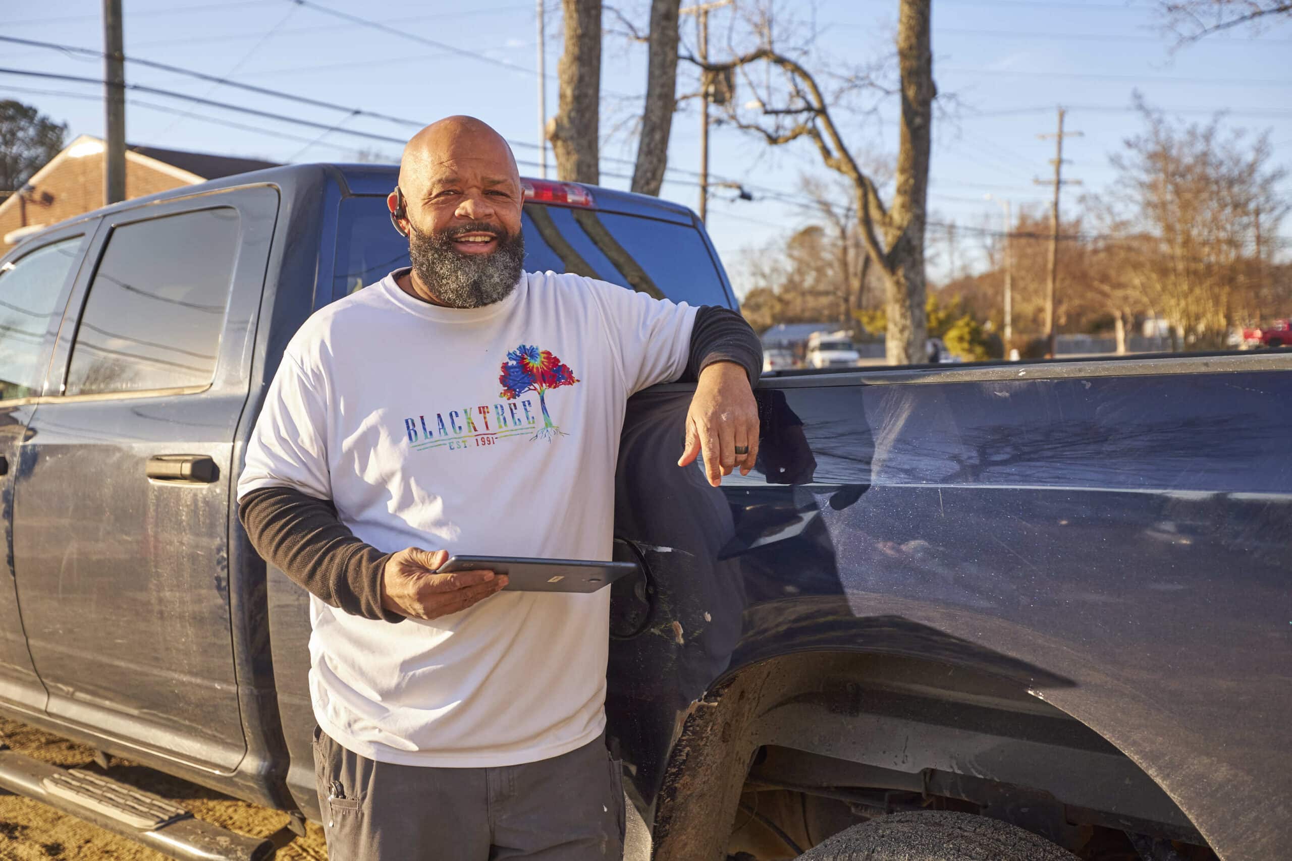 Buildxact customer John McBride outside by his truck, using Buildxact on his tablet