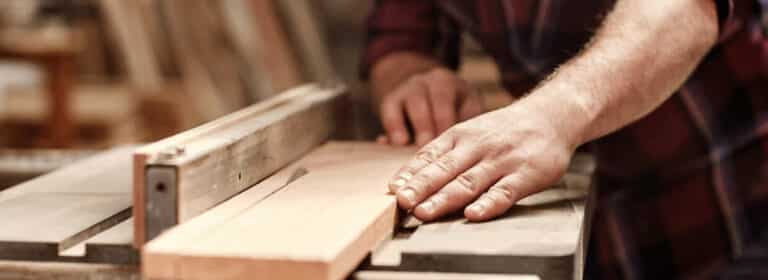 A close up of a carpenter sawing some wood