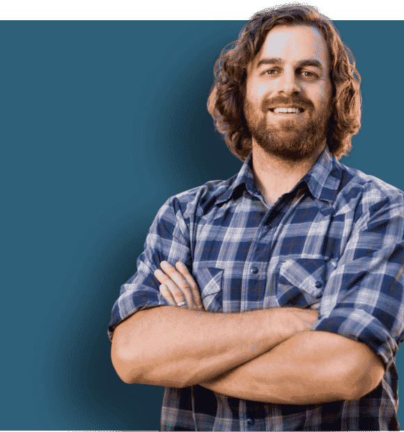 A photo of a builder with his arms crossed smiling at the camera