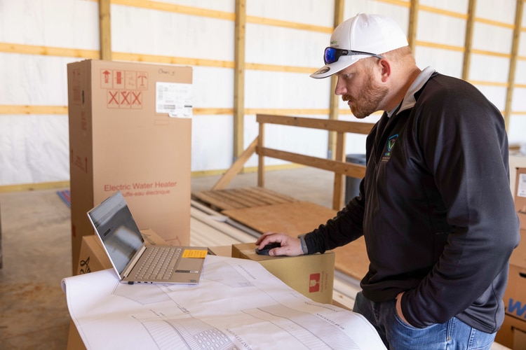 Builder Josh Bradway checks his digital measurements using a laptop