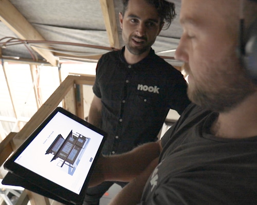 Nook Construction reviews a digital blueprint on a mobile device