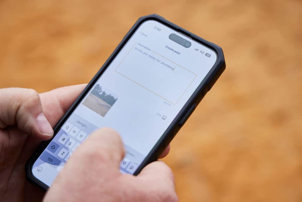 A Buildxact customer uses his mobile phone to log a project update.