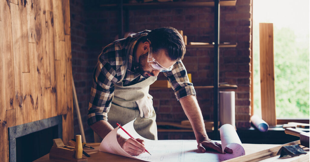 A builder working on a paper construction plan