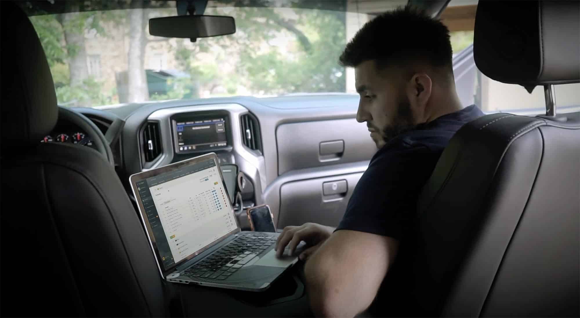Builder working on laptop in vehicle