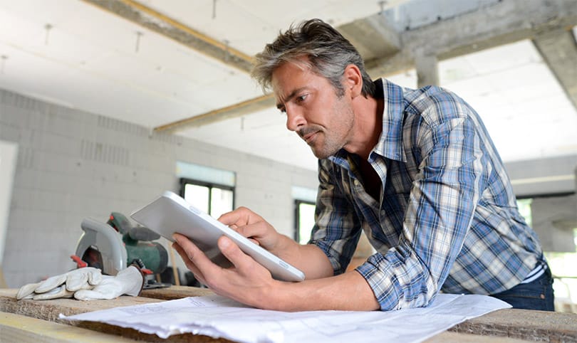 a home builder checks his job schedule using a internet device.