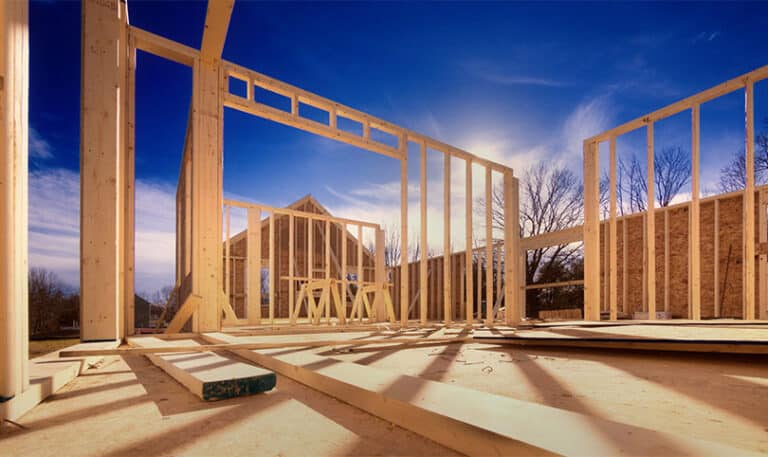 A job site with the wall framing of the house being built