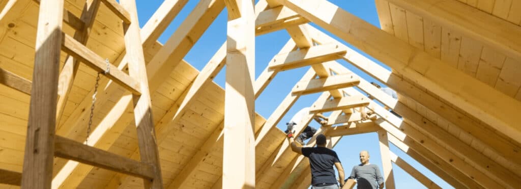 Four builders working on a timber roof