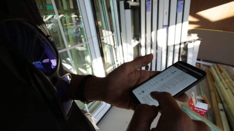 A builder uses a mobile device and Buildxact to check a To-Do List.