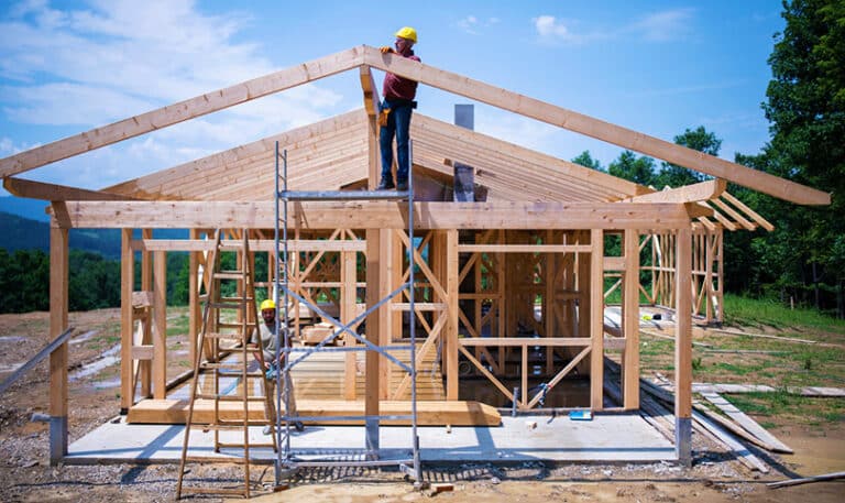 Two builders working on the framing of a house