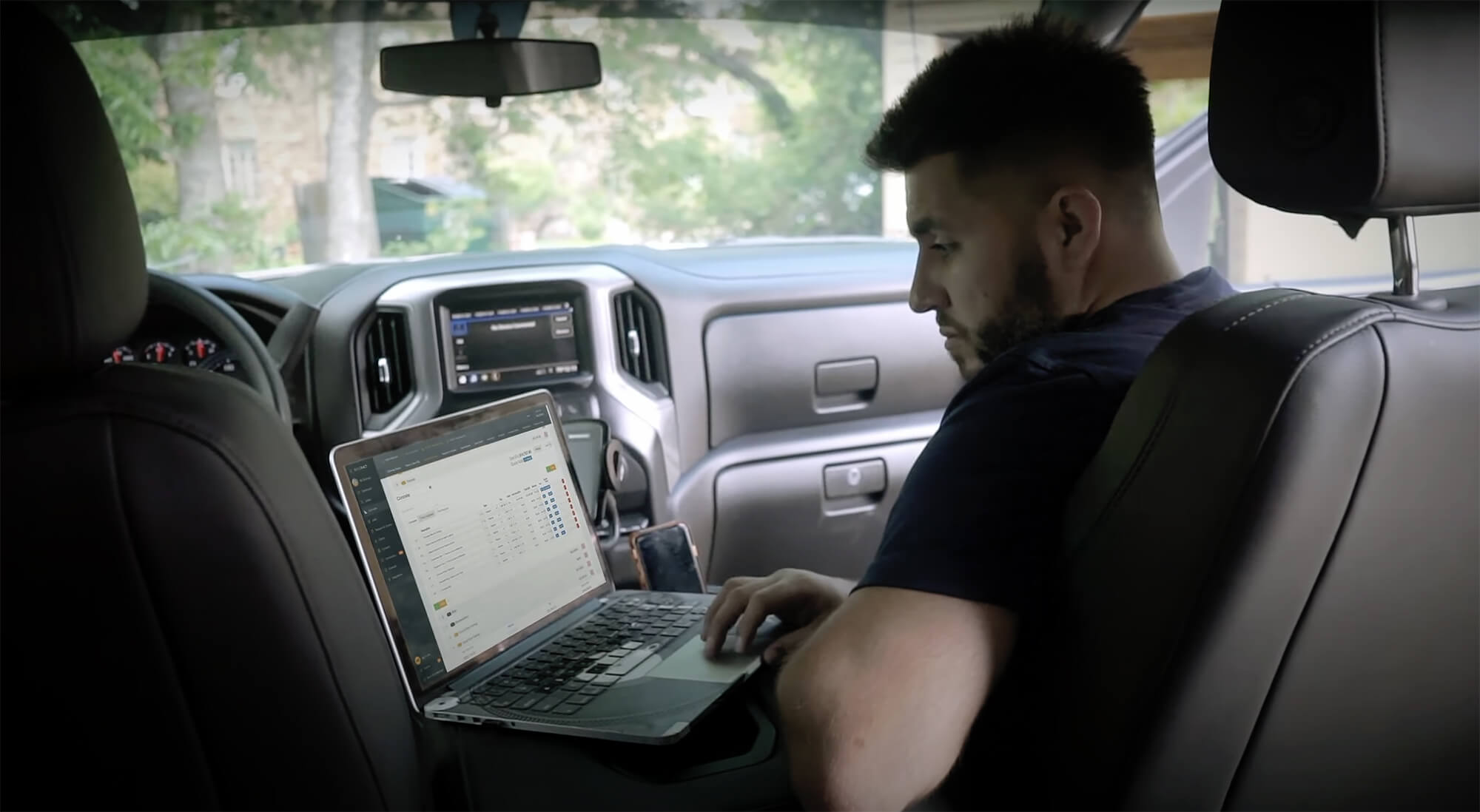 Builder working on laptop in vehicle