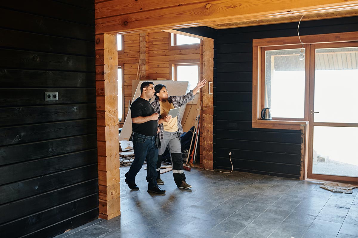 Two builders with an iPad walking through a home construction