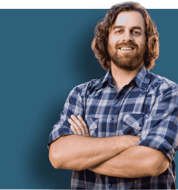 A photo of a builder with his arms crossed smiling at the camera