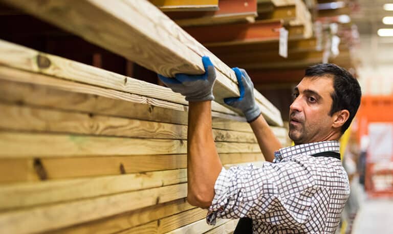 A material dealer stacks lumber in preparation for sale to home builders.