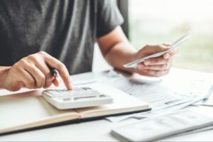 A person using a calculator to budget