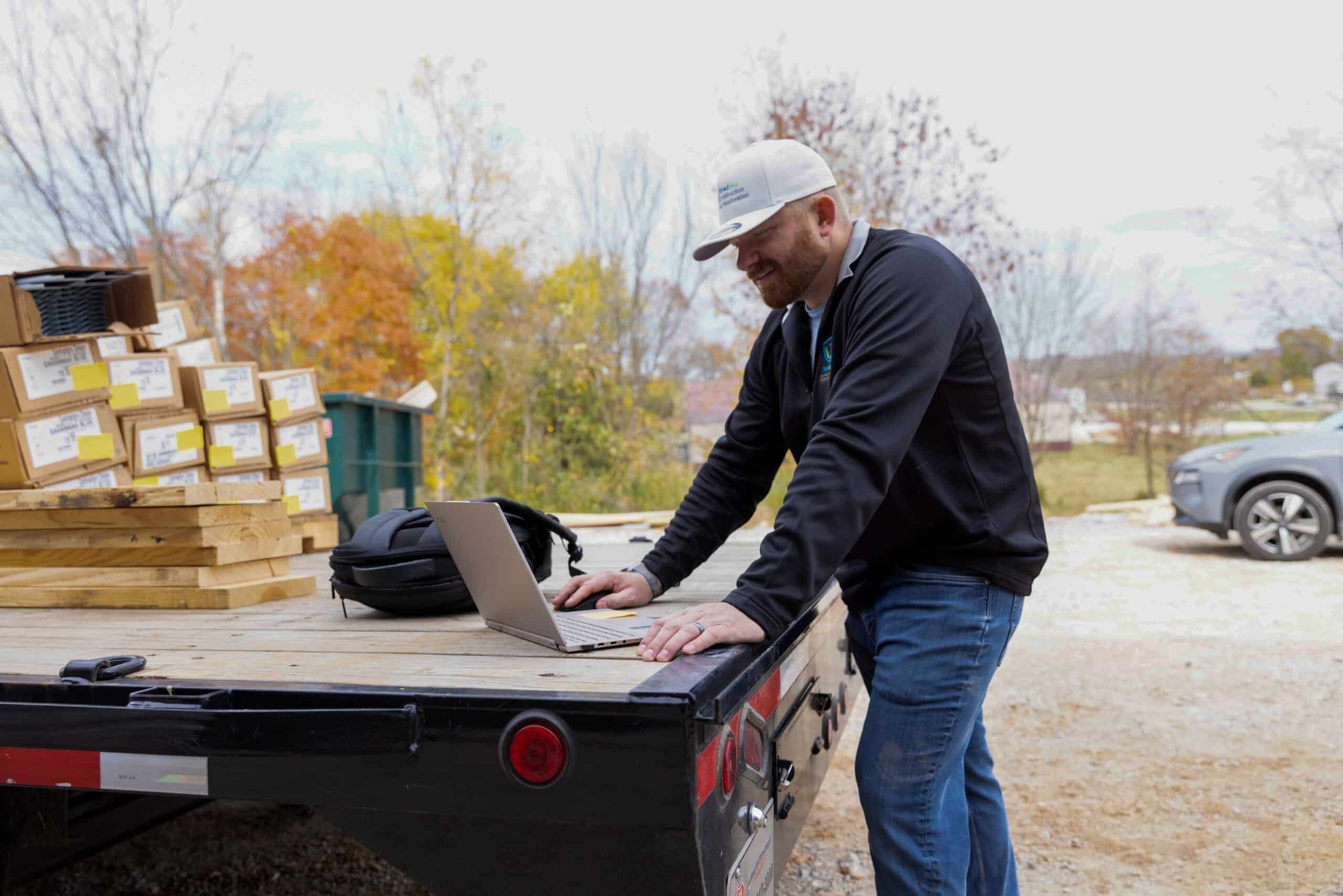 A builder reviews his project plan using a laptop.