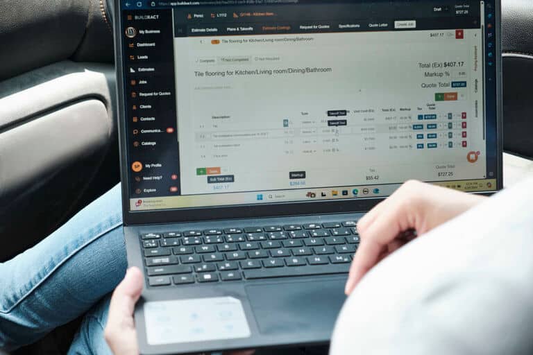 A builder estimates a project using Buildxact on his laptop.