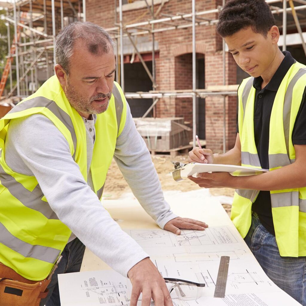 Two builders discussing plans on a construction site