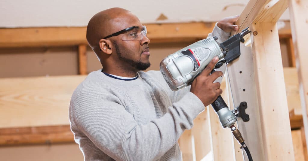 A contractor on a framing job using a pneumatic framing nailer.