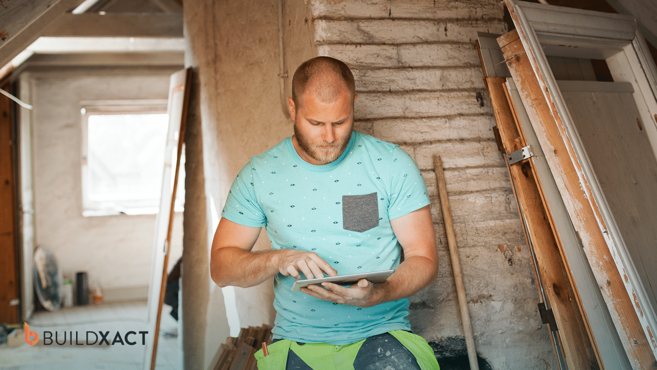 Residential builder reviewing a construction bid and cost estimate on a tablet at an active job site
